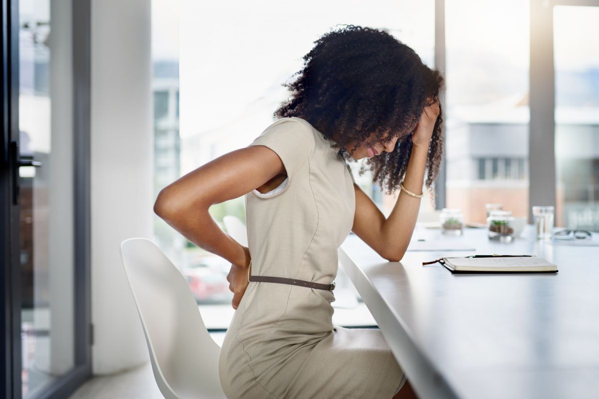 The woman feels back pain, one of the symptoms of anxiety disorder.